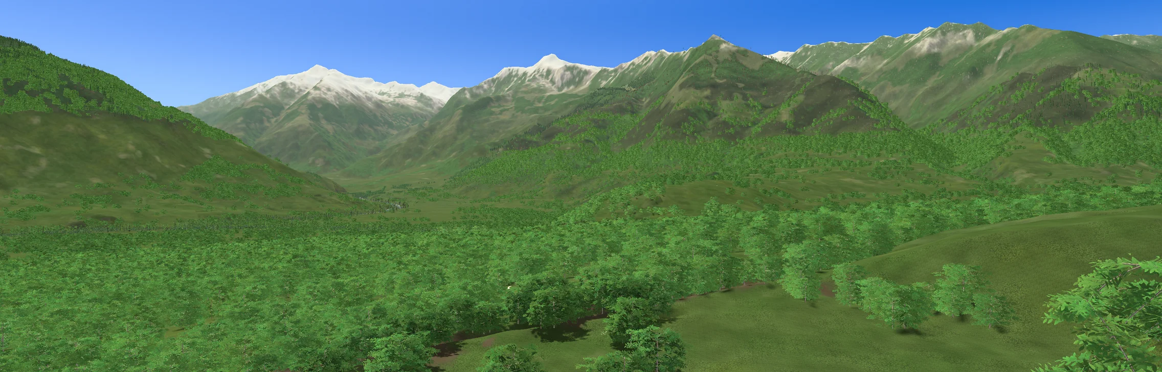 The same view rendered by the game: the valley floor in meadow and wood, the same peaks behind.