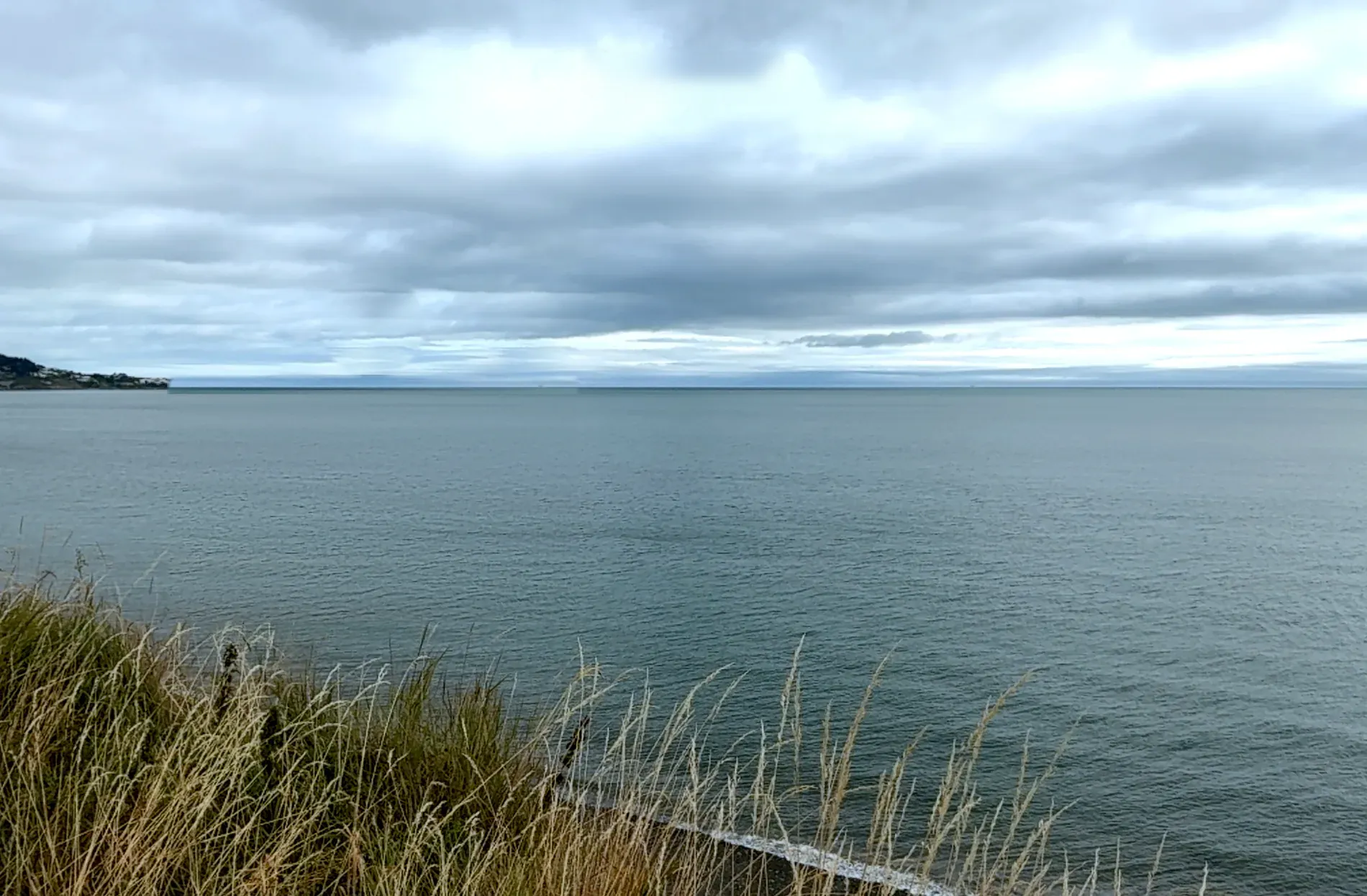 Looking out over Dublin Bay from the coast, a grey summer sky above the sea